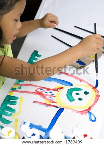 A young girl paints a colorful picture of herself.