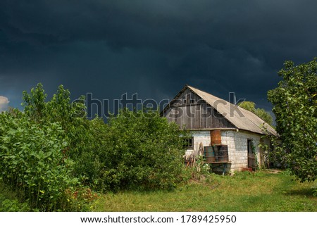 Heavy rain near an old abandoned house in a distant village. Green nature.
