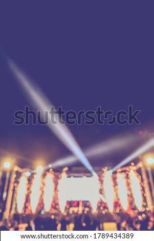 Vintage tone abstract blur image of People at musical performance concert  in night time with light bokeh for background usage .