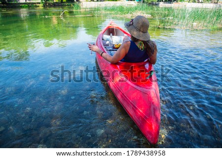 Woman paddling kayaking in beautiful river. Amazing view. Girl drinking wine in kayak in nature. 
