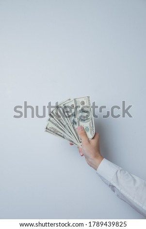 Hand holds 100 dollar bills on a white background. Empty space in the photo.