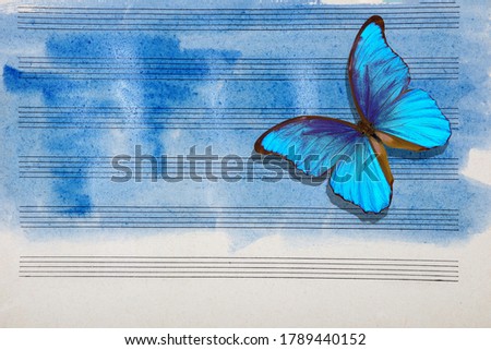 Morpho blue butterfly and notes. Butterfly melody. Old music sheet in blue watercolor paint. Blues music concept. Abstract blue watercolor background.