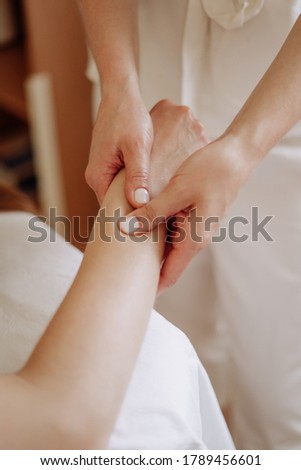 Masseuse Massaging Client Wrist Spa Salon Cabinet Close-up Photography. Professional Healthcare Treatment and Medical Massage Rejuvenate Procedure Hand. Acupressure Therapy Vertical Photo