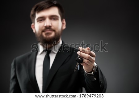 Succesful man in suit holding car keys in hand