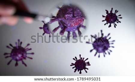 
Covid-19 virus or coronavirus observed with a magnifying glass.