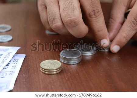 Money coins stacking by man, business and financial concept