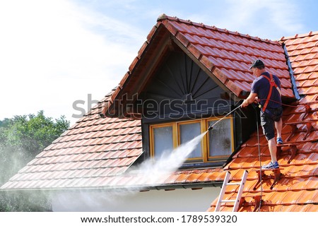 Roof cleaning with high pressure cleaner Royalty-Free Stock Photo #1789539320