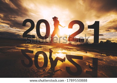 2021 Silhouette and women jumping. beautiful sunset. Concept for vision year 2021.