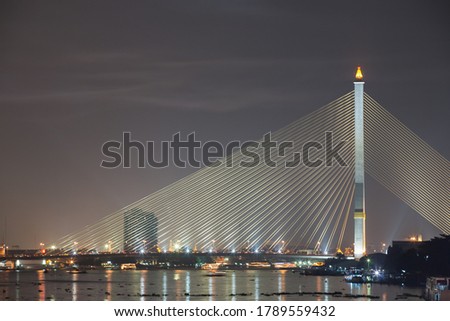 Structural of bridge across river againts night time sky