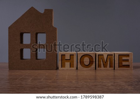 Home wording on wooden cube with a home replica. business property concept