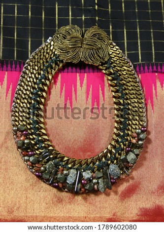 Necklace Complimenting Gold and Pink Textured Fabric
