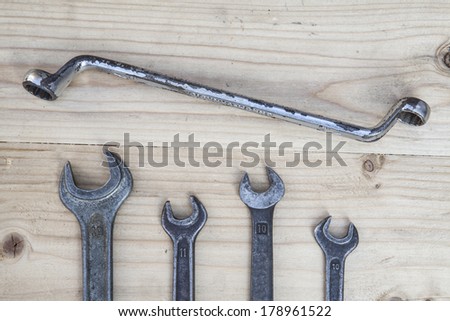 Four wrenches on a wooden board.