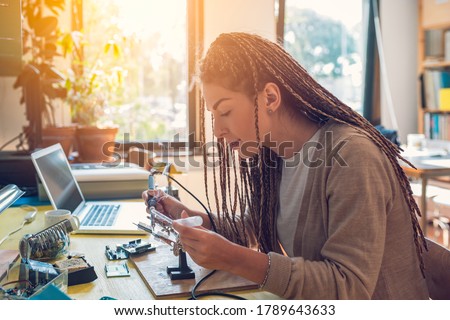 Woman electronics engineer is soldering circuit  board in her workshop stock photo Royalty-Free Stock Photo #1789643633