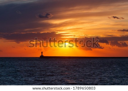 Beautiful sunset on the embankment of Sevastopol (Crimea). The sun sets in the sea. Very beautiful seascape, view of the sea, waves and sky with clouds.