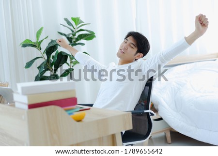 Male Asian stretch body relax on the table working at home
