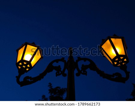lilac twilight in the city and yellow lanterns against the sky