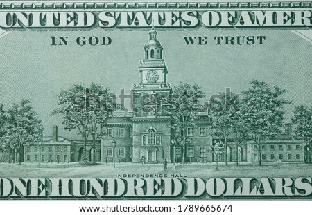 Picture of the building of Independence Hall with writings In God We Trust, printed on 100 hundred USA dollar banknote