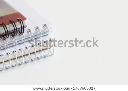 photo of several spiral bound notebooks on a white background in a minimalistic style, office theme, space for text