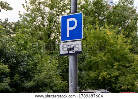 Motor car parking sign. Blue square road sign on tree background