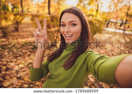 Closeup photo of optimistic pretty lovely girl lady make selfie show v-sign open mouth blogger live stream connect followers wear green sweater spend free time square garden park outside