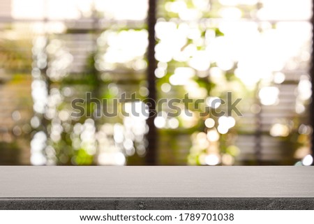 Stone table and blurred window with blinds on background