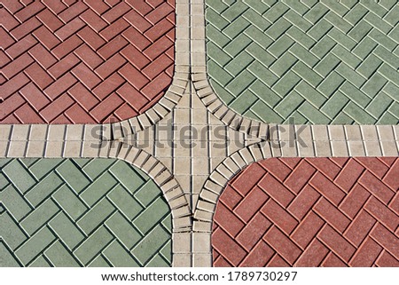 The texture of red and green paving slabs. The view from the top