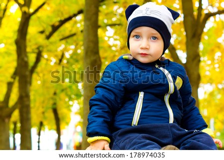 Beautiful child in a funny hat in autumn Park