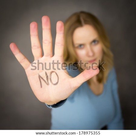 Blond woman expressing denial with NO written on her hand Royalty-Free Stock Photo #178975355