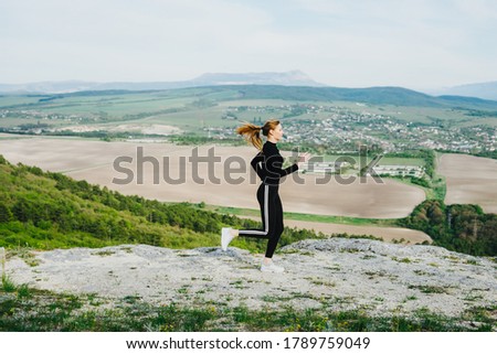 A woman runs in the mountains. Outdoor sports.