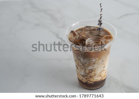 Lavander Ice coffee with cream to go, on a marble table, delicious popular drink, texture and refreshing look of the drink, coffee beverage in coffee house.Copy Space. marble background