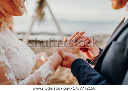 Happy Moment of exchanging beautiful diamond rings during traditional marriage outdoor ceremony. Fine jewelry for bride and groom on wedding day customs. Symbol of Eternal Love. Royalty-Free Stock Photo #1789772150