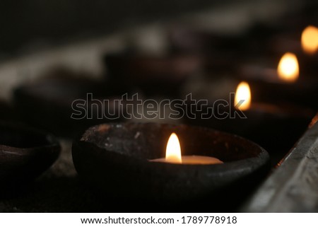 Candle lights on a traditional ceramic bowls on dark background. Holy week concept. Spiritual concepts. Royalty-Free Stock Photo #1789778918