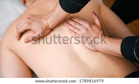 Chiropractic treatment - the doctor giving the patient a massage - pushing on the back with hands. High quality photo