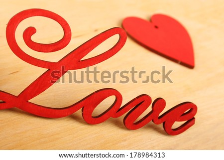 Love wooden letters on the background of the little red hearts