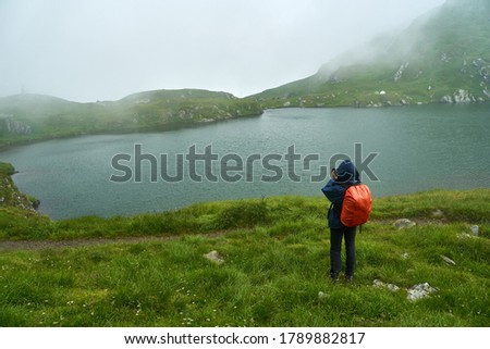 Professional photographer with camera and backpack hiking into the highlands
