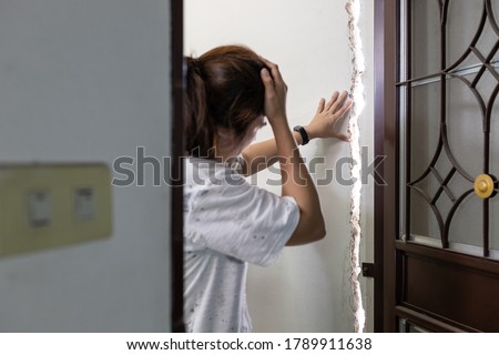 Stressed asian female people is standing at the cracks,rift of wall in her house feeling disappointed,regretted,repair or extension of substandard buildings,problems with non-standard home renovations Royalty-Free Stock Photo #1789911638
