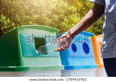 Selective focus close up the man black hand throwing an empty plastic water bottle in the recycling garbage trash or bin, environmental recycling concept  Royalty-Free Stock Photo #1789916903