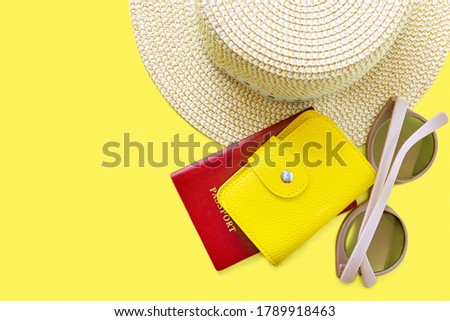 Top view of hat, sunglasses and pasport with leather purse. Summer vacation background. Summertime, travel, beach, relax, tourism concept. Yellow background with copy space. Royalty-Free Stock Photo #1789918463