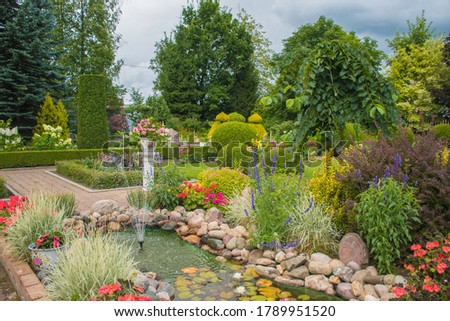 Landscape design of a garden plot: a hot summer day, plants at home in the sun, beautiful summer garden design Royalty-Free Stock Photo #1789951520