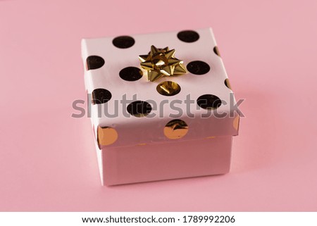 Pink gift box with golden ribbon. pink background