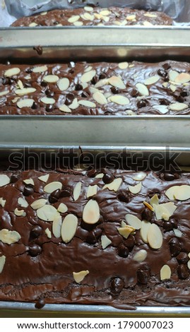 Chocolate fudge brownies with shiny crust, unfocused picture, blurry background, noise and grain texture, reflected by light