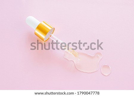 Cosmetic pipette with natural oil on a pink background close-up. Stylish concept of organic essences, beauty and health products. Copy space, minimalism, flat lay. Modern apothecary. 