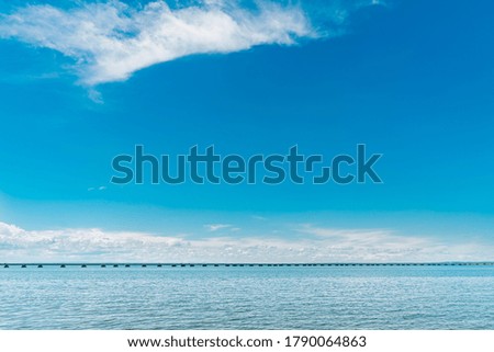 blue sea with a low water bridge and blue sky with clouds
