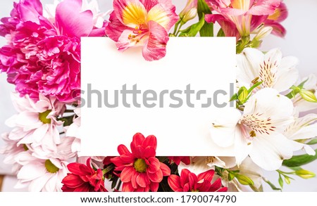 White paper card note laying in bright flowers bouquet. Romantic wedding invitation. Present for women. Birthday greeting card. Mother`s day. Space for text. Place for text Royalty-Free Stock Photo #1790074790