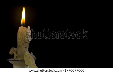 Burning candle on a black background close-up. With a place to insert text.
