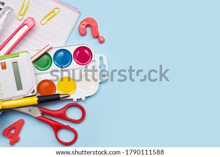 Colorful school stationery on blue background with a copy space