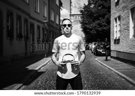 Portrait of man with headphone in his hand, look in camera. Black and white photo of Dj