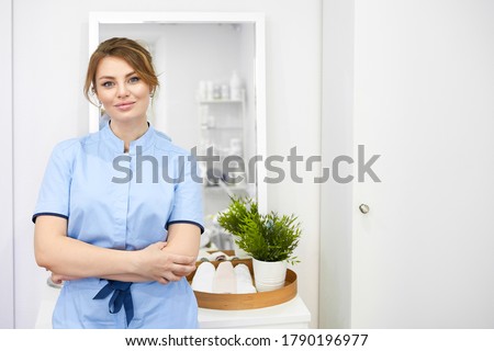 Happy successful young woman cosmetologist on the background of the beauty office. Portrait of prosessional beautician Royalty-Free Stock Photo #1790196977