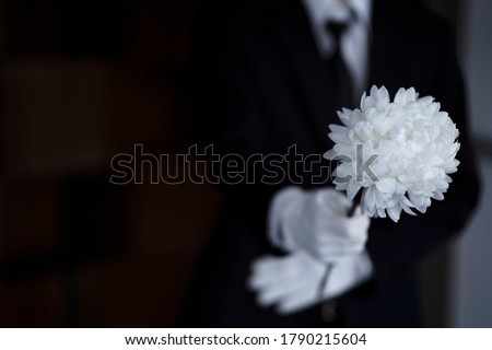 Bereaved holding flowers at funeral Royalty-Free Stock Photo #1790215604
