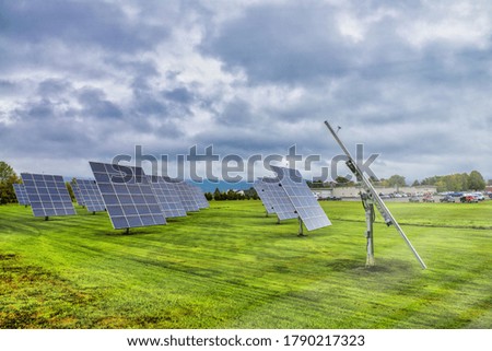 Solar panels at sunrise with cloudy sky in the countryside. Solar energy, modern electric power production technology, renewable energy concept. Environmentally friendly electricity production.